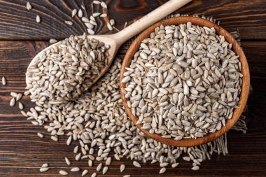 Koyu ahşap arka planda ayçiçeği tohumları.