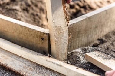 İnşaatçı tahtadaki vidayı çevirir..