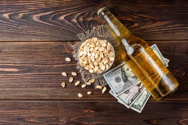 Koyu ahşap arka planda tuzlu fıstık birası..