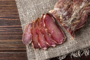 Koyu ahşap arka planda kurutulmuş domuz eti.