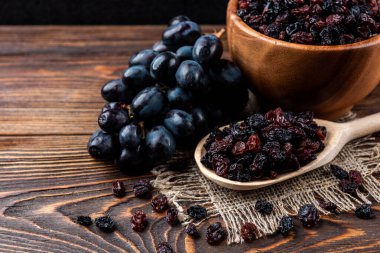 Koyu ahşap arka planda üzüm ve üzümler.