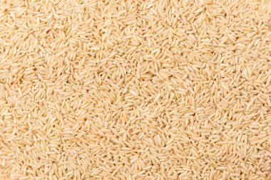 Brown rice background with spoon.
