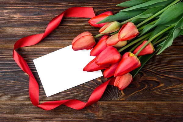 Červené Tulipány Červenou Stuhou Blahopřání Tmavém Dřevěném Pozadí — Stock fotografie