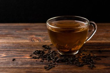 Koyu ahşap arka planda bir fincan siyah çay..