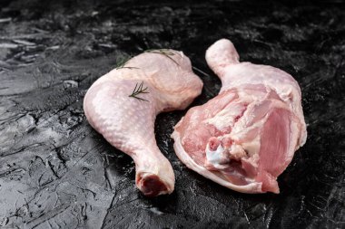 Siyah arka planda çiğ tavuk bacağı.