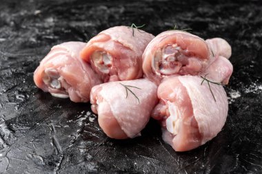 Siyah arka planda çiğ tavuk bacağı.