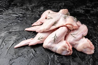 Siyah arka planda çiğ tavuk kanadı.