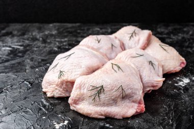 Siyah arka planda çiğ tavuk budu..