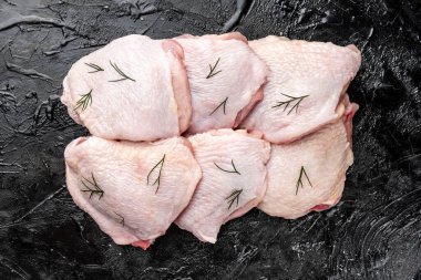 Siyah arka planda çiğ tavuk budu..