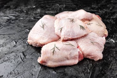 Siyah arka planda çiğ tavuk budu..