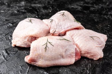 Siyah arka planda çiğ tavuk budu..