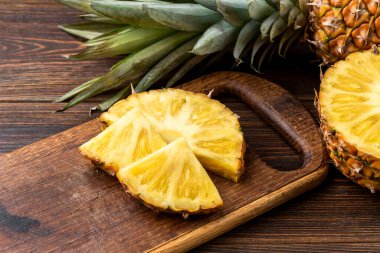 Koyu ahşap arka planda ananas kesimi.