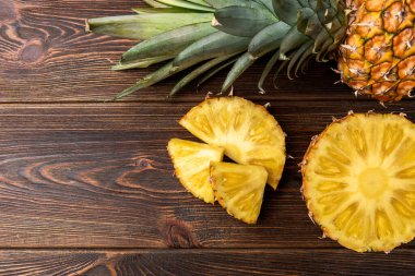 Koyu ahşap arka planda ananas kesimi.