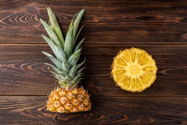 Koyu ahşap arka planda ananas kesimi.