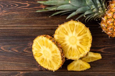 Koyu ahşap arka planda ananas kesimi.