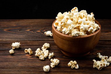 Koyu tahta arka planda patlamış mısır.