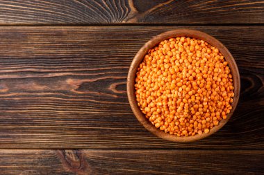 Koyu ahşap arka planda kırmızı mercimek.