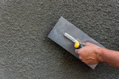 İnşaat aracı kullanılarak duvardaki dekoratif alçı uygulaması. 