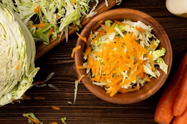 Koyu ahşap arka planda lahana ve havuç kesmek. Taze salata..