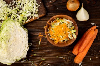 Koyu ahşap arka planda lahana ve havuç kesmek. Taze salata..