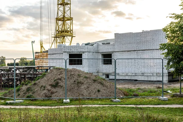Gökyüzünün arka planında vinç olan yüksek katlı bir bina inşa ediliyor. İnşaat alanı.