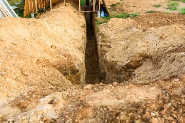 Siper kazıyorum. Toprak işleri, çukur kazma. Boru ya da optik fiber döşemek için kazılmış uzun toprak siperi.