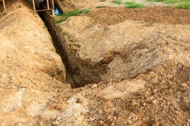 Siper kazıyorum. Toprak işleri, çukur kazma. Boru ya da optik fiber döşemek için kazılmış uzun toprak siperi.