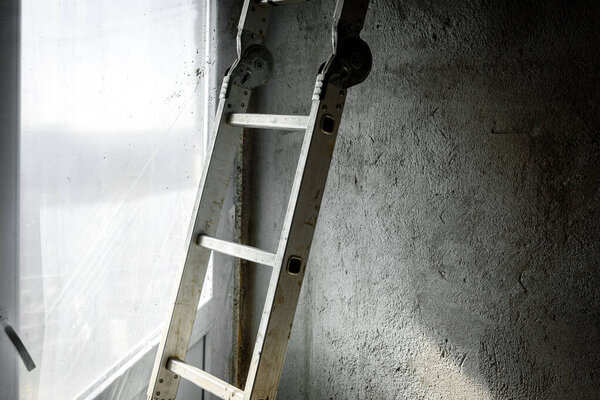Ladder on concrete wall, construction site.