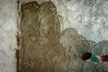 İşçi duvara mala sıva uyguluyor..