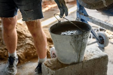 İnşaat işçisi mikserde beton yapıyor..