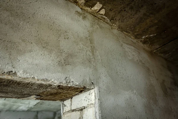 Plaster on beacons on a brick wall. Installation of metal guiding beacons for filling and leveling of walls in the repair.