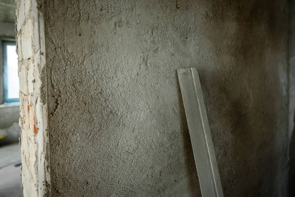 Plaster on beacons on a brick wall. Installation of metal guiding beacons for filling and leveling of walls in the repair.