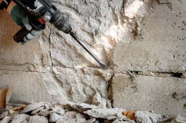 İnşaat alanında kaya matkabı kullanan adam..