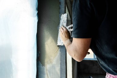 Pencerenin yamaçlarında onarım var. Pencerenin kenarlarına alçı tabakası koyma işlemi.