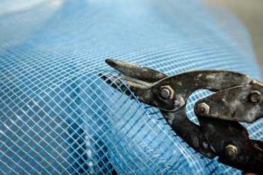 İşçi inşaat alanındaki ön cephe şebekesini kesiyor.