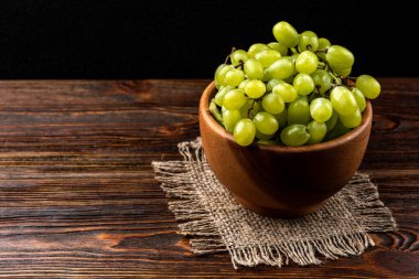 Koyu ahşap arka planda yeşil üzüm.