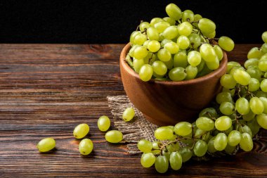 Koyu ahşap arka planda yeşil üzüm.