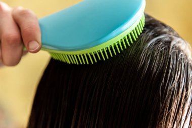 Kadın banyodan sonra saçını tarıyor..