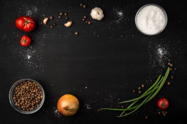 Siyah zemin üzerinde soğan, domates, sarımsak, patates ve karabiber..