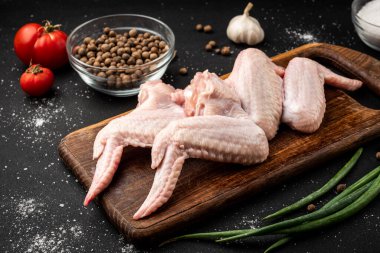 Siyah arka planda çiğ tavuk kanadı.