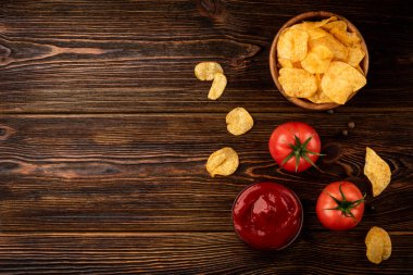Koyu ahşap arka planda domatesli cips..