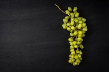Siyah arkaplanda yeşil üzüm.