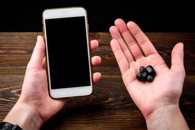 Siyah kablosuz kulaklık ve cep telefonu..