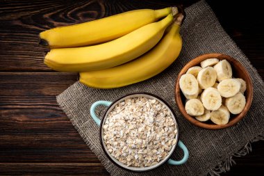 Muz ve yulaf ezmesi koyu ahşap arka planda.