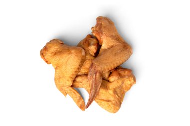 Tütsülenmiş tavuk kanatları beyaz arka planda izole edilmiş.