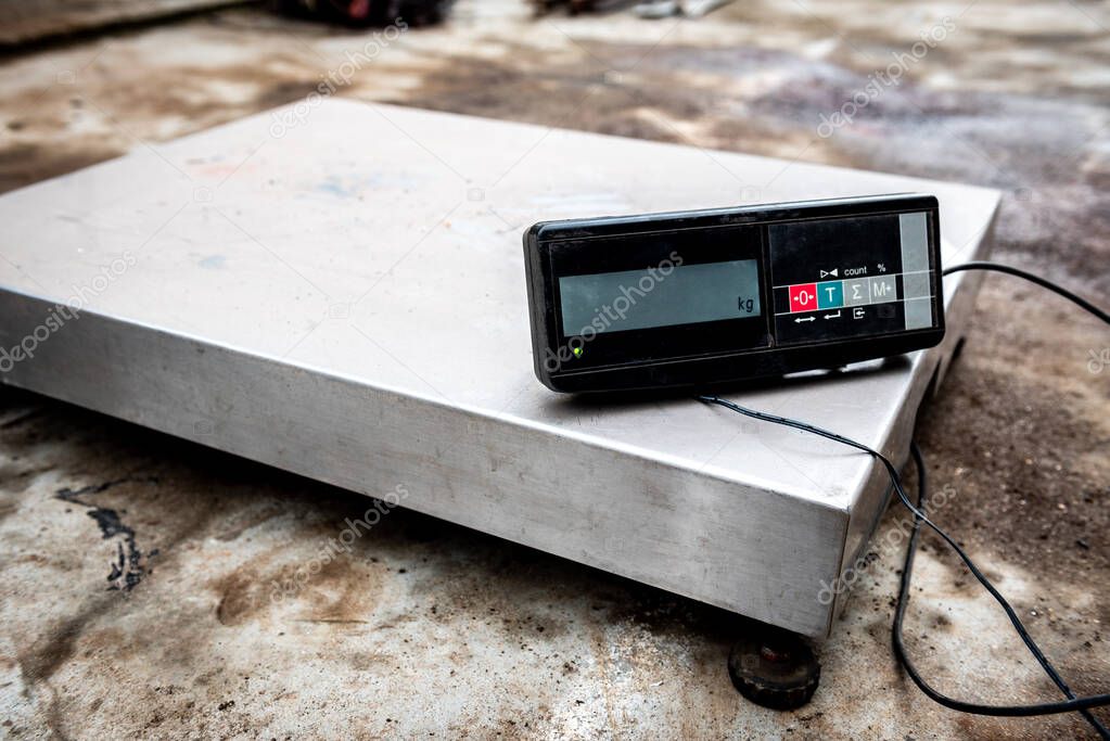 Warehouse digital platform scales on concrete background.