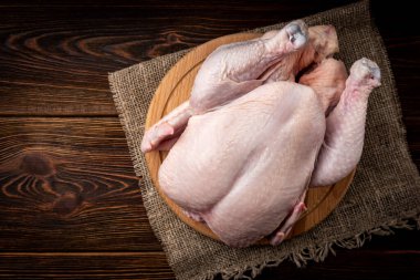 Tahtada çiğ tavuk, ahşap arka planda..