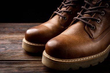 Koyu ahşap arka planda kırmızı deri çizmeler..