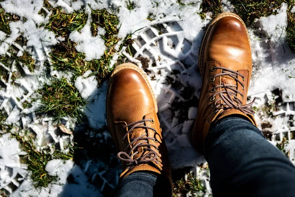 Woman wearing leather boots in winter frozen nature.