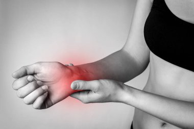 Gri arka planda el ele tutuşan bir kadın..